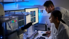 Two healthcare provider in a dark room looking at a screen