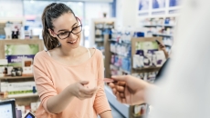 Patient picking up a prescription at a retail pharmacy