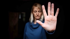 Person showing stop sign with hand