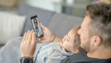 Person sitting on a couch with another person on their lap during a telemedicine call