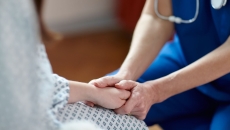 A nurse holding a patient's hands
