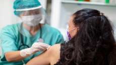 A provider preparing a vaccine for a patient