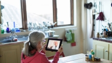 person holding tablet sitting at table