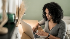 Person sitting at a desk while looking at a computer