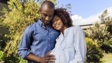 A man posing with a pregnant woman