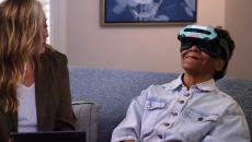 Patient using a Rendever headset while sitting next to another individual