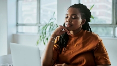 Person in orange shirt looking at computer screen