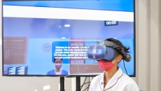 A nursing student wearing a VR lens demonstrates the use of the Virtual Hospital learning system
