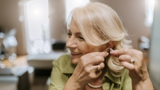 Person adjusting their hearing aid