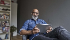 Person sitting in a chair while looking at a tablet