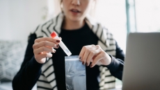 A woman putting a test sample in a bag to return in the mail.