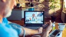 Patient taking their blood pressure while on a video call with a provider