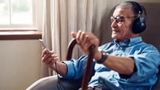 An older man using his smartphone in his home