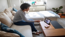 An older woman talking to a provider using a tablet.