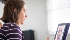 A woman talks to a provider on her tablet