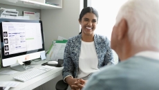 A mental healthcare provider talking to an older patient in the foreground