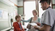 Healthcare provider with a patient and their caregiver in a clinic