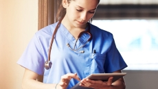 A doctor scrolling through a tablet