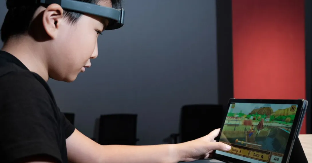 A child playing the new Cogo game while wearing the SenzeBand 2, an EEG headband by Neeuro