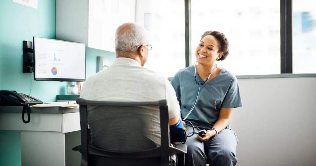 Healthcare provider with a patient sitting next to a computer