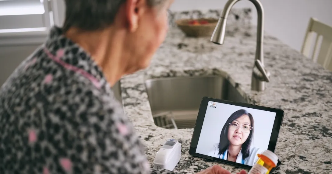 Person interacting with healthcare professional via tablet