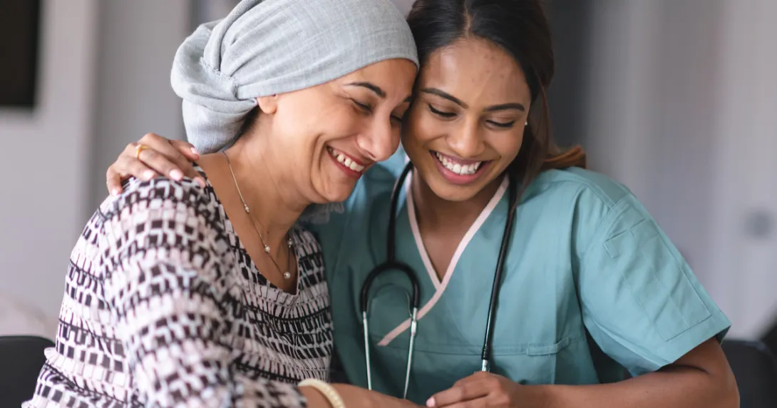 Two people sitting with one embracing the other