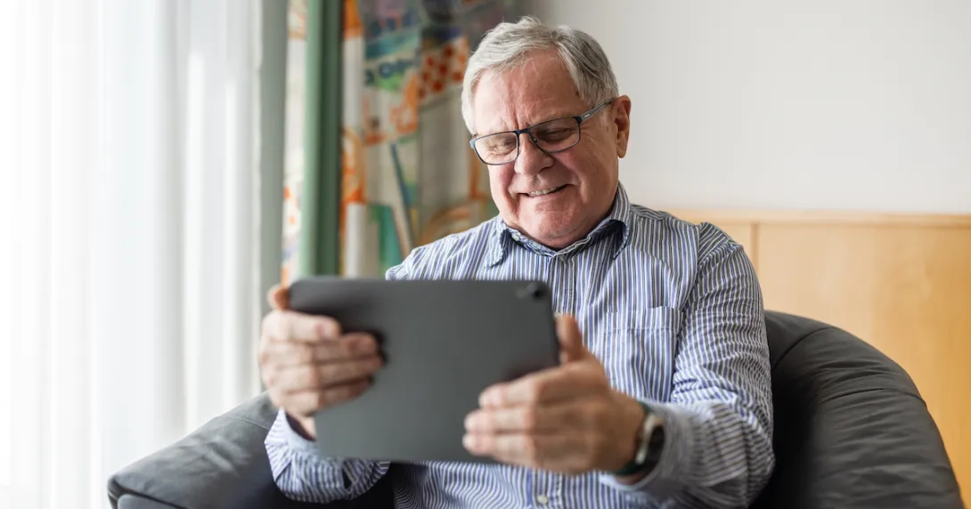 Person sitting on a chair while looking at a tablet
