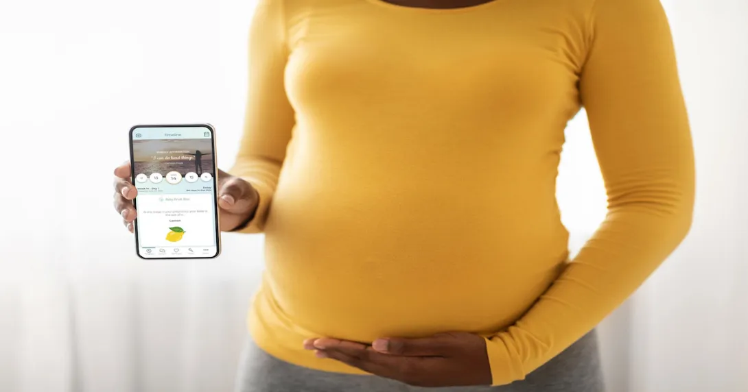 A pregnant women holding a smartphone with the PALS app