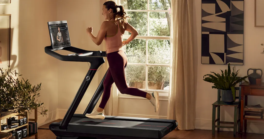 A woman running on a Peloton treadmill