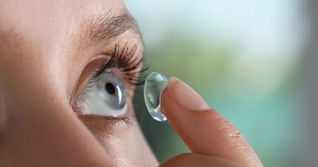 Person inserting a contact lens into their eye