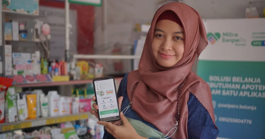 A pharmacist showing the SwipeRx mobile app