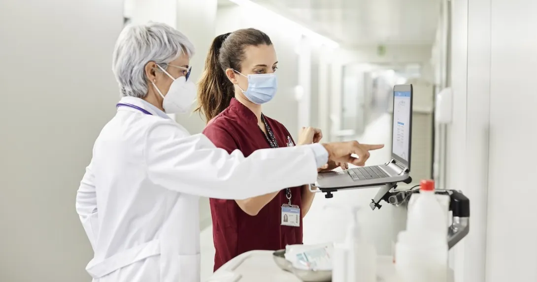 Clinicians reviewing data on a laptop