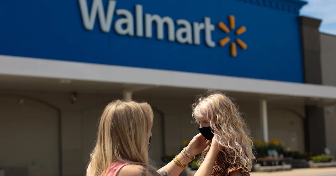 Walmart customer, puts a mask on her daughter outside a Walmart store