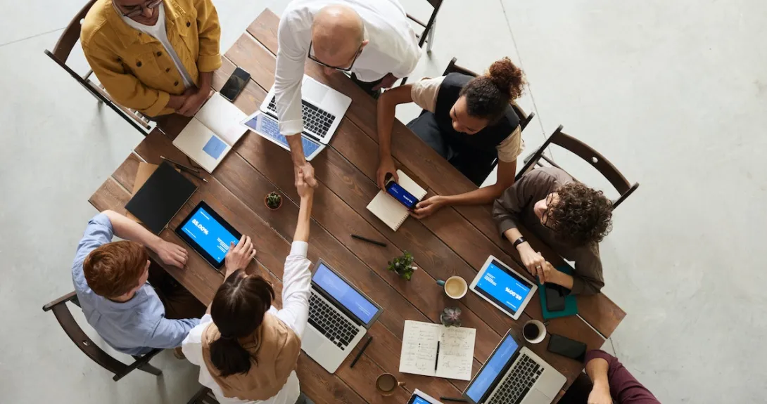 People shaking hands at a conference table