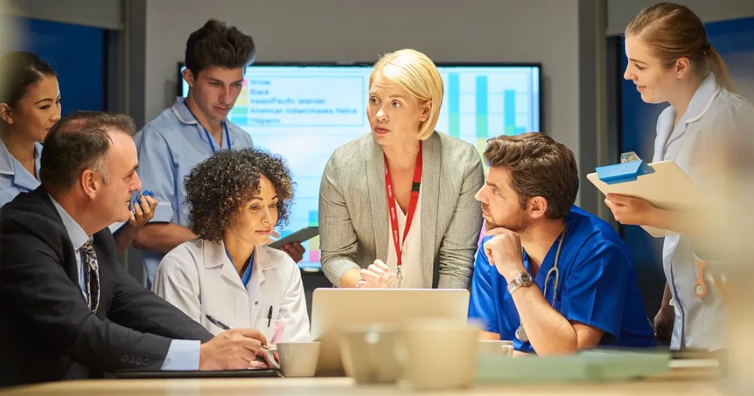 A group of businesspeople and providers talking in a conference room during a presentation.