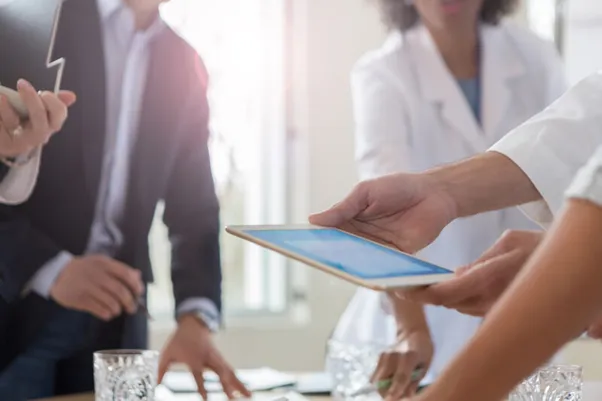 Business professionals and healthcare workers in a discussion.