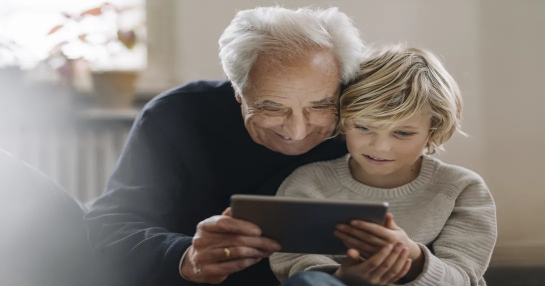 An older man and a child using a tablet