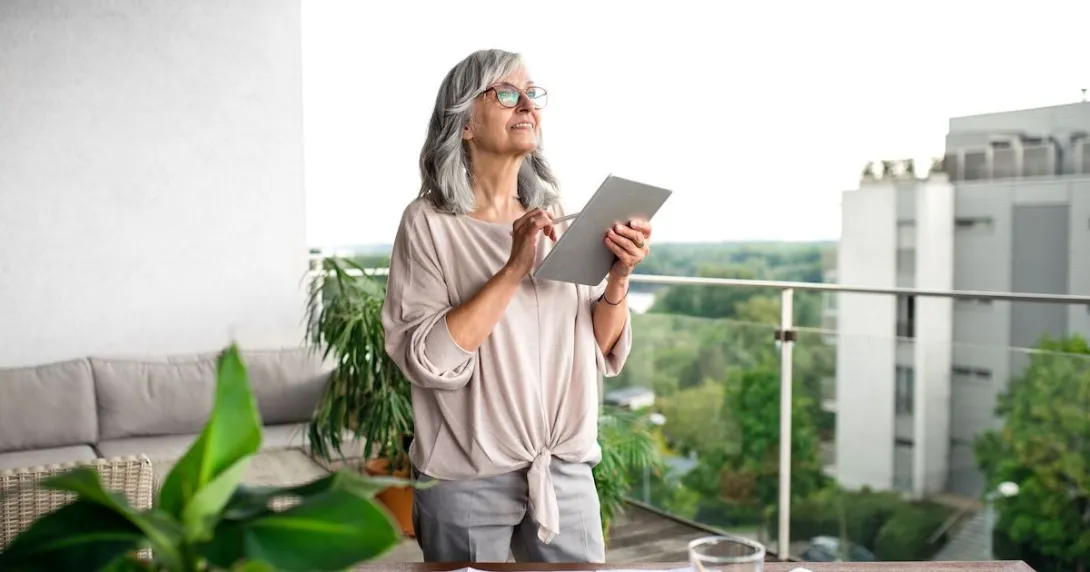 An older woman using a tablet at her desk