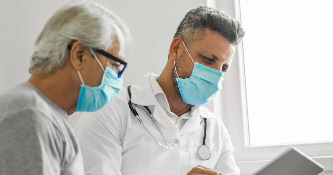 An older man and his doctor looking at a tablet