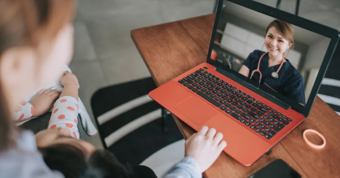 Two people sitting on a couch talking to a telehealth provider