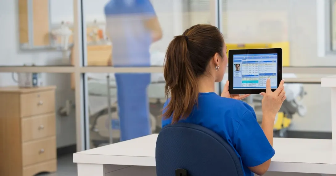 Healthcare provider sitting at a desk in the clinical setting while looking at a computer