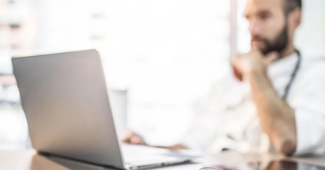 Healthcare provider sitting at a desk with a computer on it