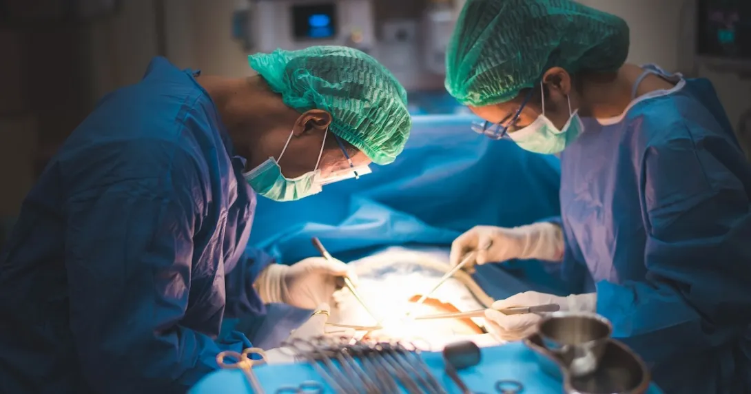 Two surgeons operating on a body