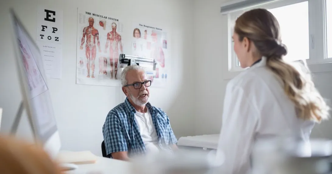 A senior patient in an in-person consultation with a doctor in a clinic